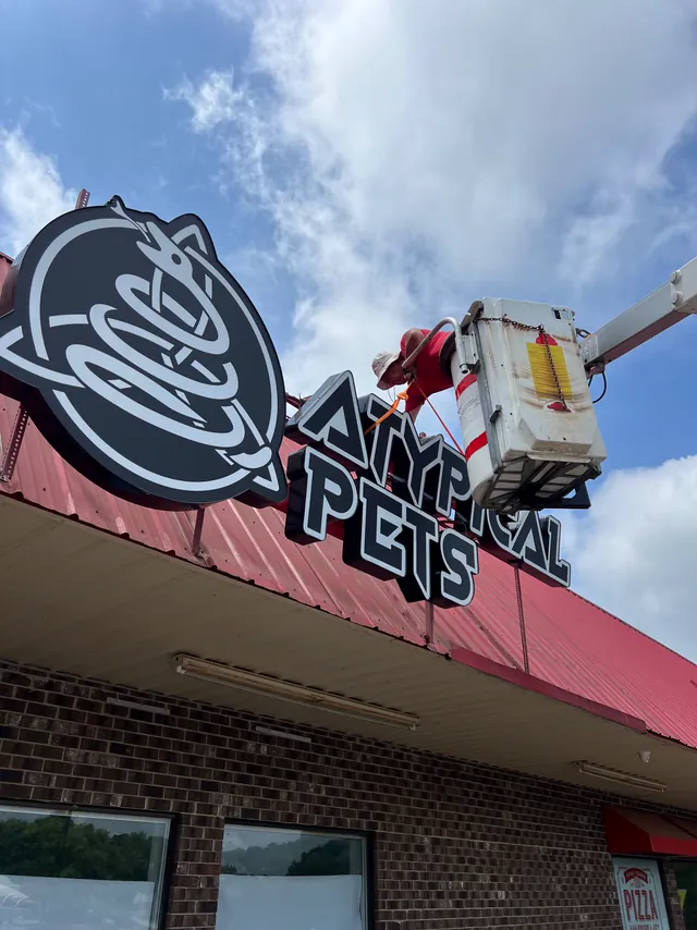 A W&W installer in a bucket truck putting up a storefront sign